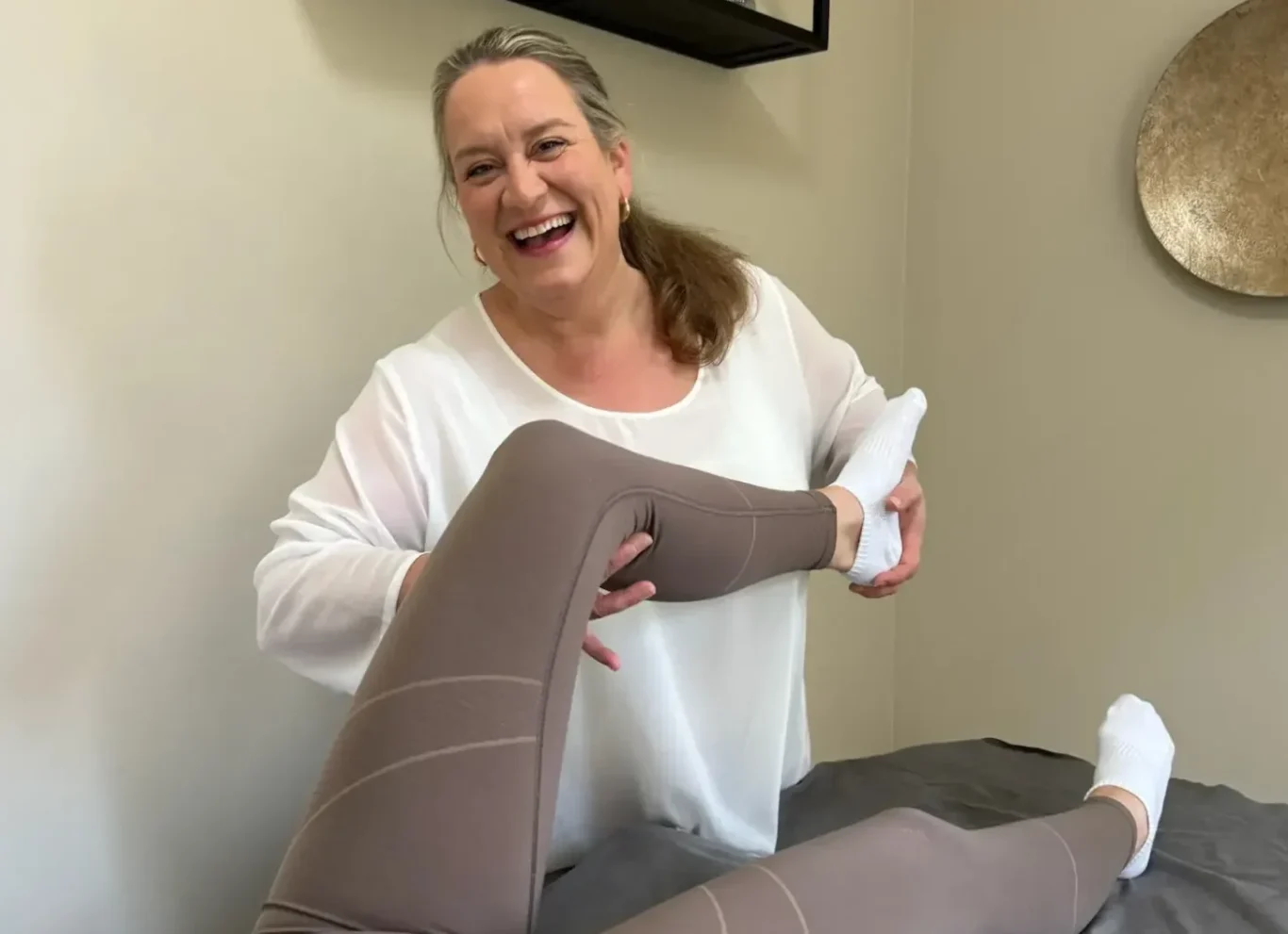 Individuelle Physiotherapie in persönlicher Atmosphäre Physiotherapeutin bei einer individuellen Behandlung des Beins in ihrer Praxis in Bakum